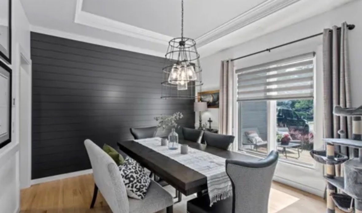 Dining room after painting with white trim, light gray walls and a charcoal shiplap accent wall