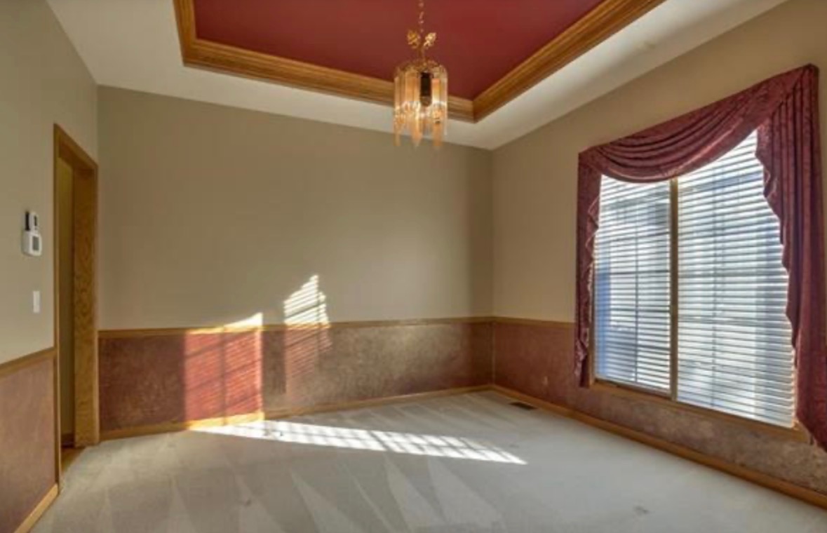 Dining room before painting with beige walls, oak trim and burgundy tray ceiling